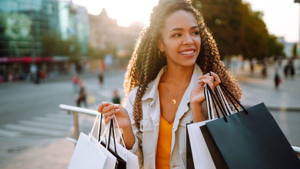 Young woman walking on the street with a bunch of shopping bags