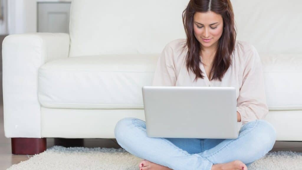 Woman sitting on the floor working on laptop